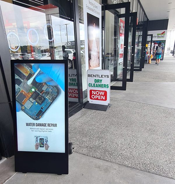 freestanding outdoor digital a board positioned outside a storefront