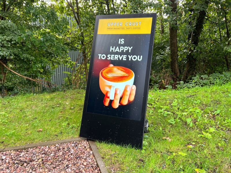 outdoor digital a-board advertising screen promoting offers outside a restaurant cafe