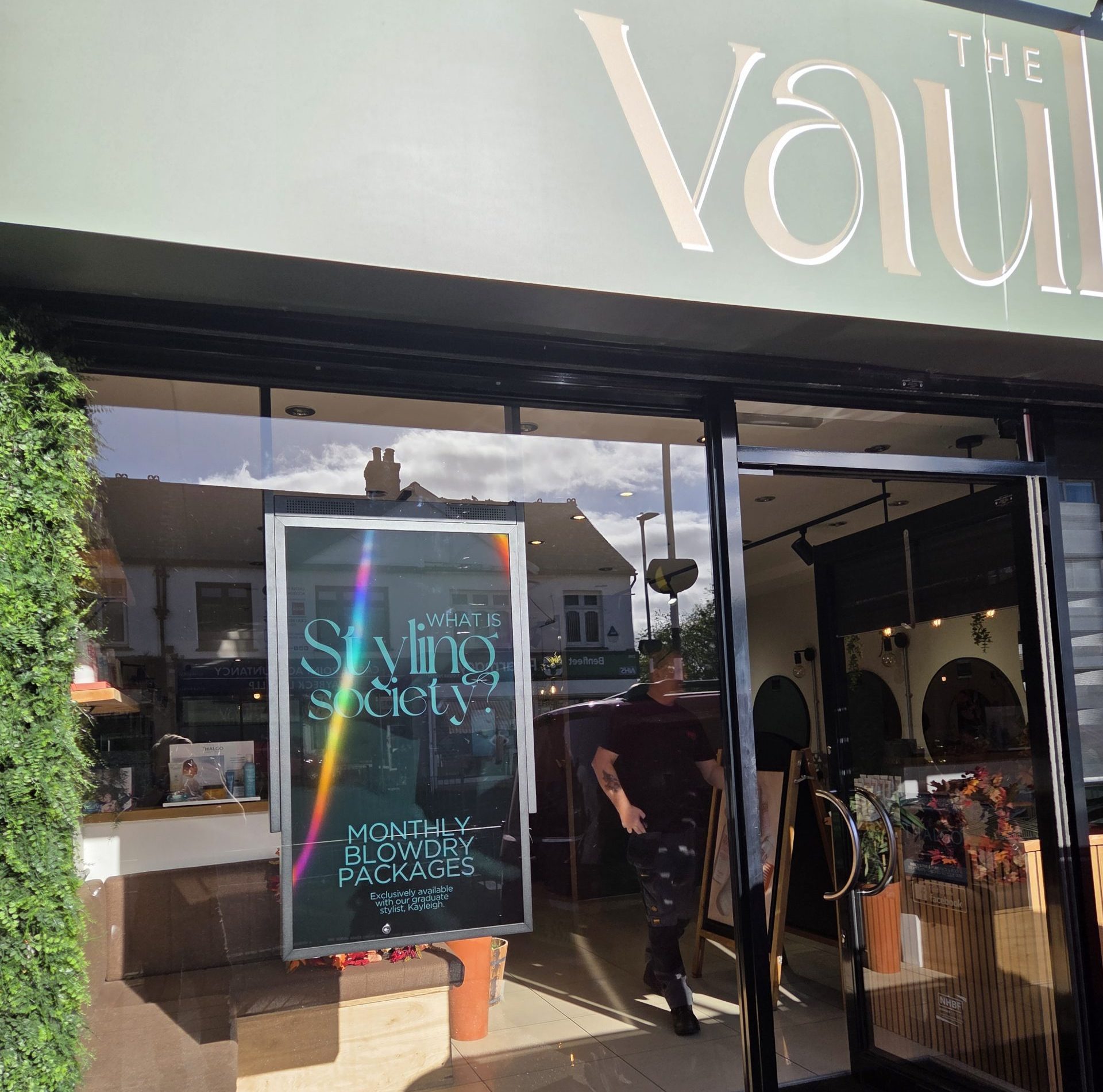 Digital signage screen in a salon shop window promoting treatments and pricing