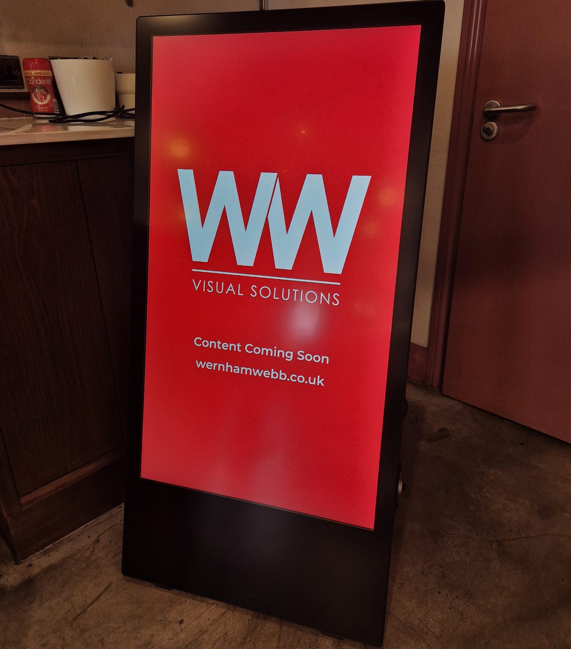 freestanding indoor digital a-board used for advertising offers within a commercial space